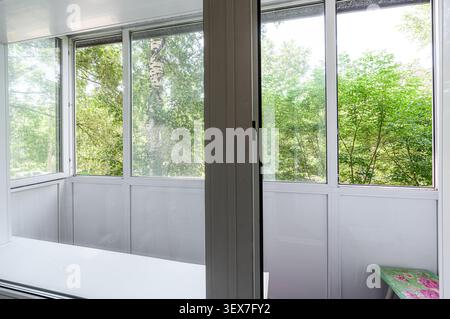 Blick von einem Balkon mit weißen Rahmen mit Blick auf üppig grüne Bäume Stockfoto