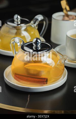 Obsttee mit Mango und Minze in einer Teekanne aus Glas auf dem Tisch Stockfoto