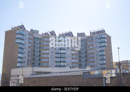 Modernes mehrstöckiges Wohnhaus, fotografiert unter einem klaren blauen Himmel bei Tageslicht. Chisinau, Moldau - 23. März 2026 Stockfoto