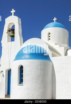 Griechisch-orthodoxe St.-Nikolaus-Kirche in Protaras, Zypern, mit weißen Wänden, blauen Kuppeln, Kreuzen und Glockenturm unter einem klaren Sommerhimmel Stockfoto