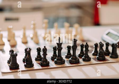 Schwarze Schachfiguren, die vor dem Turnierspiel an Bord angeordnet wurden Stockfoto