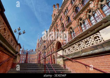 Sehr detaillierte Fassade eines kunstvollen, roten Backsteingebäudes in der viktorianischen Ära in London mit komplizierten Steinmetzwerken, Bögen und dekorativen Elementen. Stockfoto