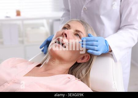 Zahnarzt überprüft die Zähne der Frau in der Klinik, Nahaufnahme Stockfoto