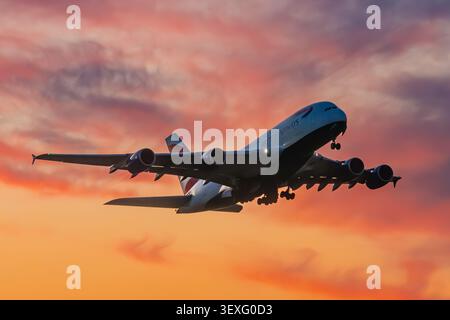 British Airways Airbus A380 Superjumbo Passagierflugzeug startet vom Flughafen London Heathrow in einen dramatischen orange Sonnenuntergang Himmel, Großbritannien. Stockfoto