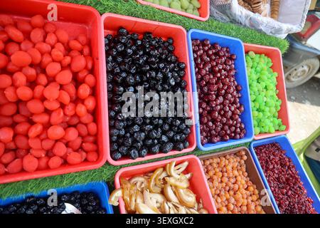 Farbenfrohe Auswahl an kandierten Früchten und getrockneten Beeren, ausgestellt an einem traditionellen Marktstand in Kaschmir Indien, lebendige süße Snacks und lokale Speisen. Stockfoto