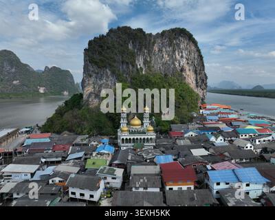Blick aus der Vogelperspektive auf das schwimmende Dorf Koh Panyi mit seiner goldenen Kuppelmoschee, eingebettet in eine riesige Kalksteinkarstformation in Ko Panyi, Phang Stockfoto