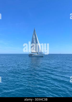 Während der Regatta der Bank of Spain gleitet eine Segelyacht sanft über das offene Meer unter Segeln. Javea, Spanien - 24. Mai 2025. Stockfoto