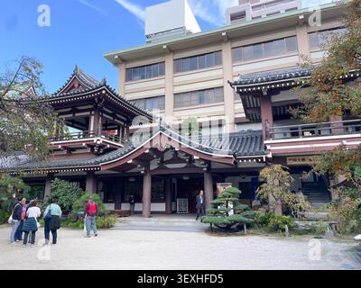 Schöner japanischer buddhistischer Tempel mit traditioneller Architektur, kunstvollen Dächern und Besuchern vor der Haupthalle. Fukuoka, Japan - 2. November Stockfoto