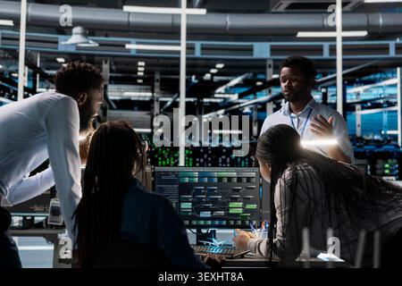 Das Engineering-Team verwendet einen PC in einem Rechenzentrum, um vernetzte neuronale KI-Netzwerke zu visualisieren und gleichzeitig Informationsverarbeitungssysteme zu überwachen. Stockfoto