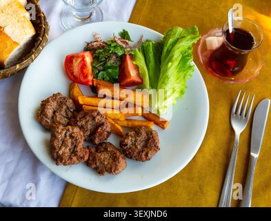 Türkische gegrillte Fleischbällchen, Inegol Kofte auf dem Teller Stockfoto