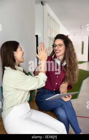 Glückliche weibliche Kollegen im Coworking Office Stockfoto