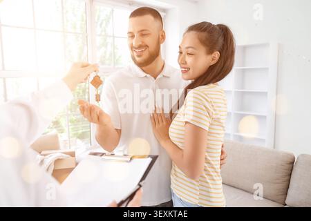 Ein paar, das Hausschlüssel von einem Immobilienmakler erhält Stockfoto