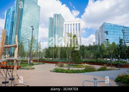 Moderner Spielplatz in urbaner Umgebung, umgeben von hohen Gebäuden und Grün. Verbesserung, Verschönerung, Renovierung der städtischen Umwelt, Verbesserung Stockfoto
