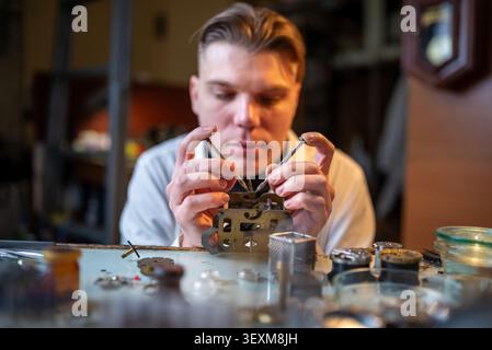 Uhrmacher repariert antike mechanische Taschenuhr auf übersichtlicher Werkbank Stockfoto