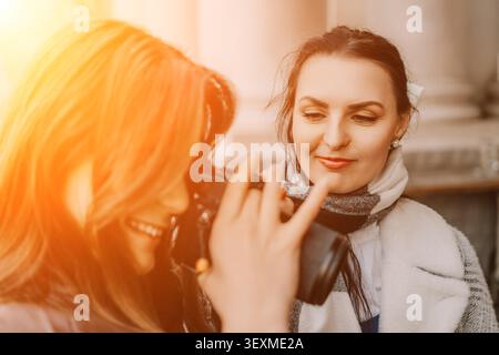 Freunde Kamerafotografie zwei junge Frauen lächeln während einer warmen goldenen Stunde in der Stadt Stockfoto