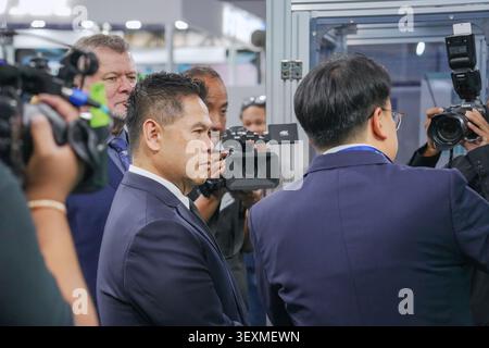 Bangkok, Thailand - 17. Juni 2026: Geschäftsmann umgeben von Pressefotografen und Videofilmen auf der Manufacturing Expo in Bangkok Stockfoto
