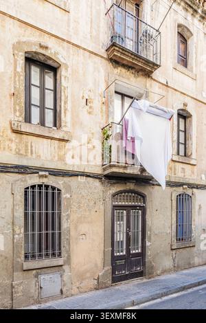 Barcelona - Spanien - 27.05.2026: Hängende weiße Wäscherei auf dem Balkon der alten rustikalen Gebäudefassade, Vintage Wohnhaus, alte Mauer Stockfoto