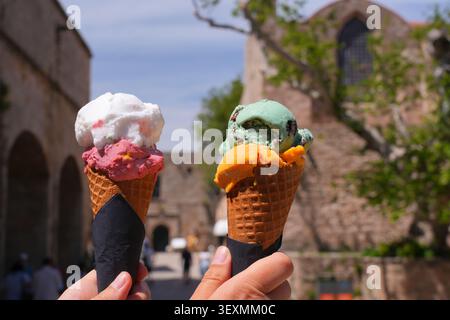Eis in der Altstadt von Rhodos in Griechenland. Hände halten buntes Eis im Kegel. Stockfoto