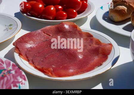 Bresaola luftgetrocknete Rindfleischscheiben. Italienisches Essen auf einem Frühstücksteller. Stockfoto