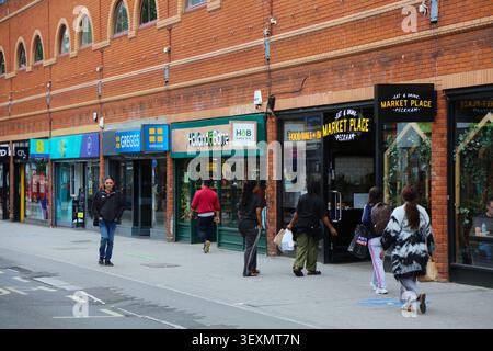 LONDON, Großbritannien - 8. JULI 2024: Die Menschen laufen auf der Rye Lane entlang des Aylesham Centre Mall im Stadtteil Peckham im Londoner Stadtteil Southwark. Stockfoto