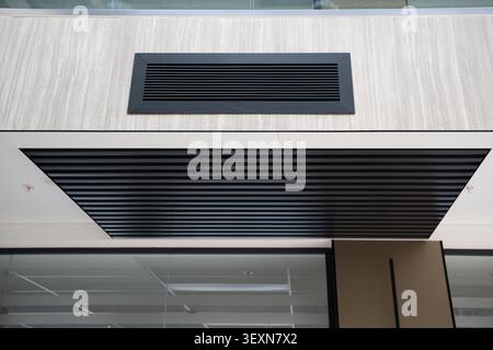 Moderne Bürofassade mit klaren architektonischen Linien und zeitgenössischen Deckendetails in einem Firmengebäude. Unternehmensarchitektur und modernes DE Stockfoto