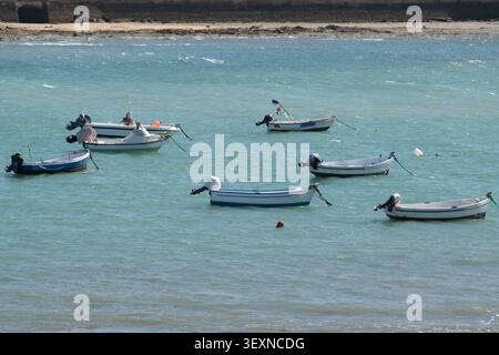 Kleine Fischerboote ruhen in flachem Wasser während der Niedrigwasserphase in der historischen Bucht von La Caleta in Cadiz; Spanien. Stockfoto