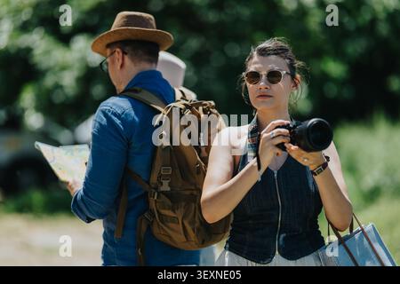 Touristen erkunden die Natur mit Kamera und Karte, während sie im Sommer Rucksacktouren und Besichtigungen Unternehmen Stockfoto