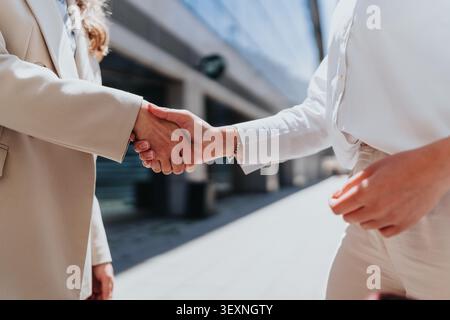 Geschäftspartner schütteln sich nach einem Meeting im Freien die Hände und besiegeln so eine professionelle Partnerschaft Stockfoto
