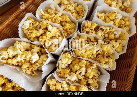 Ein Popcorn-Snack gelb salzig knusprige Papierbehälter Essen Kinoparty im Korb, perfekt zum Teilen und Genießen bei Versammlungen oder Filmnähe Stockfoto
