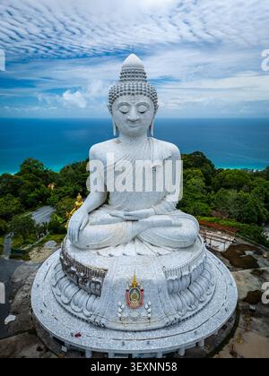 Blick aus der Vogelperspektive auf die große Buddha-Statue aus weißem Marmor auf einem Hügel mit Blick auf die Andamanensee, umgeben von üppigen tropischen Wäldern in Phuket, Thail Stockfoto