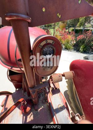Nahaufnahme eines roten Vintage-Traktors, Fahrzeugmaschine, die die Geschichte der Landwirtschaft und den Charme der Landschaft widerspiegelt Stockfoto