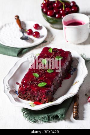 Schokoladen-Kirschkuchen mit Kirschsauce und frischer Minz-Garnitur Stockfoto