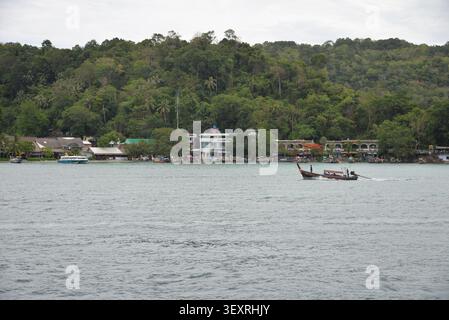 Phi Phi Inseln, Thailand – 18. Mai 2026: Boote vor Anker in der Bucht, umgeben von hohen Kalksteinklippen und tropischer Küste auf den Phi Phi Inseln Stockfoto