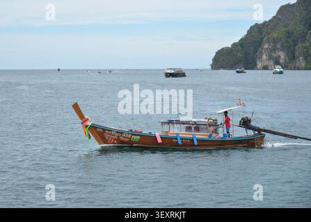 Phi Phi Inseln, Thailand – 18. Mai 2026: Boote vor Anker in der Bucht, umgeben von hohen Kalksteinklippen und tropischer Küste auf den Phi Phi Inseln Stockfoto