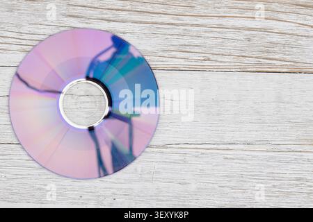 Glänzende CD auf heller Holzoberfläche symbolisiert Datenspeicherung, Technologie und digitale Medien, ideal für Backup, Archivierung, und technisch relevante Conep Stockfoto