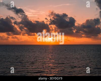 Sonnenuntergang über Dhigurah Island, Malediven, mit Wolken und Meeresleuchten Stockfoto