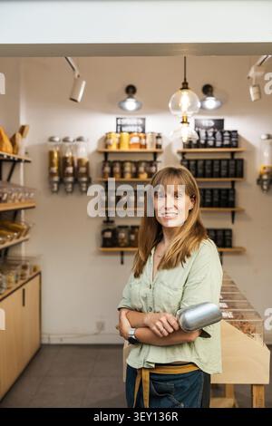 Frau, die natürliche gesunde Lebensmittel im Zero Waste Store verkauft Stockfoto