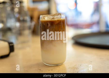 Ein erfrischender Nahaufnahme von Eismokka-Kaffee, serviert in einem hohen Glas. Das Getränk enthält reichhaltige Schokolade, Espresso und kalte Milch mit Eiswürfeln. Stockfoto