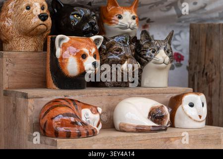 Chiang Mai, Thailand - 27. Mai 2026 : Tierkopfförmige Keramikvasen und Schlafkatzenfiguren auf Holzregal Stockfoto