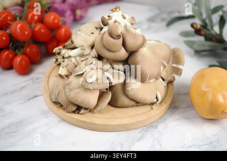 Pilze auf einem Holzteller mit frischem Gemüse in der Nähe Stockfoto