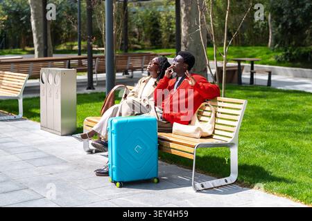 Sorglose afroamerikanische Touristen Paare Mann und Frau genießen Ruhe, während sie auf dem grünen Platz sitzen. Stockfoto