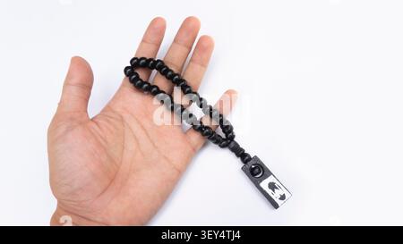 Schwarze tasbische Gebetskerlen in Palm, isoliert auf weiß Stockfoto