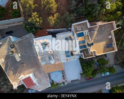 Top-Down-Shot zeigt in Griechenland Dächer von Wohngebäuden mit Solarthermiekollektoren und Wasserkesseltanks. Stockfoto