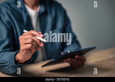 Eine Nahaufnahme einer Mann-Hand-Geste, die sich ausgibt, um einen Vertrag zu unterzeichnen, zeigt diese geschäftliche Pose einen professionellen Mann, der einen digitalen Stift für eine wichtige Arbeit verwendet Stockfoto
