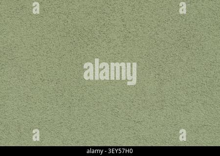 Nahaufnahme einer grünen strukturierten Oberfläche mit feiner, körniger Textur und leichten Unebenheiten, die ein Hintergrund- oder Hintergrundbild erzeugt. Stockfoto