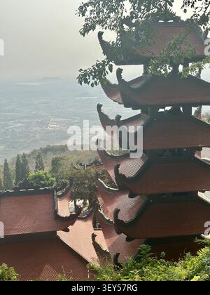 Buddhistischer Pagode Turm mit Blick auf ein malerisches Tal von einem Berg. Eine wunderschöne mehrstufige traditionelle Tempelpagode steht hoch oben auf einem Berg, Angebot Stockfoto
