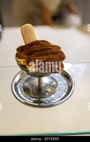 Ein luxuriöser Nahaufnahme des klassischen Tiramisu-Desserts, serviert in einem stilvollen Metallkelch. Schichten aus kaffeegetränkten Löffelbiskuits (kedi dili) mit cremiger Mascarpone Stockfoto
