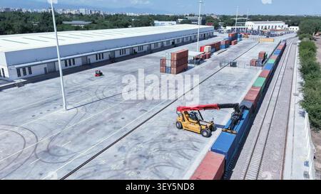 (260702) -- ALMATY, July 2, 2026 (Xinhua) -- An aerial drone photo taken on June 25, 2026 shows a staff member operating a crane to handle containers of the China-Europe freight train at the Kazakhstani land port for Xi'an in Almaty, Kazakhstan.  In November 2013, the first Chang'an China-Europe freight train departed from Xi'an to Almaty in Kazakhstan, making the two cities ever since become key transit hubs along Asia-Europe transportation route.    Since the first China-Central Asia Summit held in 2023, China and Kazakhstan have innovated their modes of cooperation by launching modern logis Stockfoto