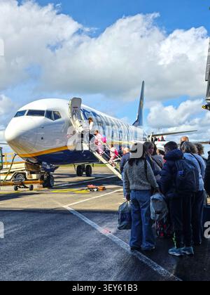 Passagiere, die auf der Landebahn stehen, um an Bord eines Ryanair-Fluges zu gehen Stockfoto