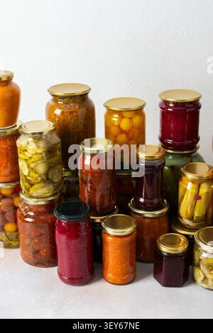 Gemüse- und Obstkonserven werden auf einem Regal für den Wintergebrauch vorbereitet. Verschiedene Gläser enthalten verschiedene Konserven, was die sorgfältigen Bemühungen um St. Stockfoto